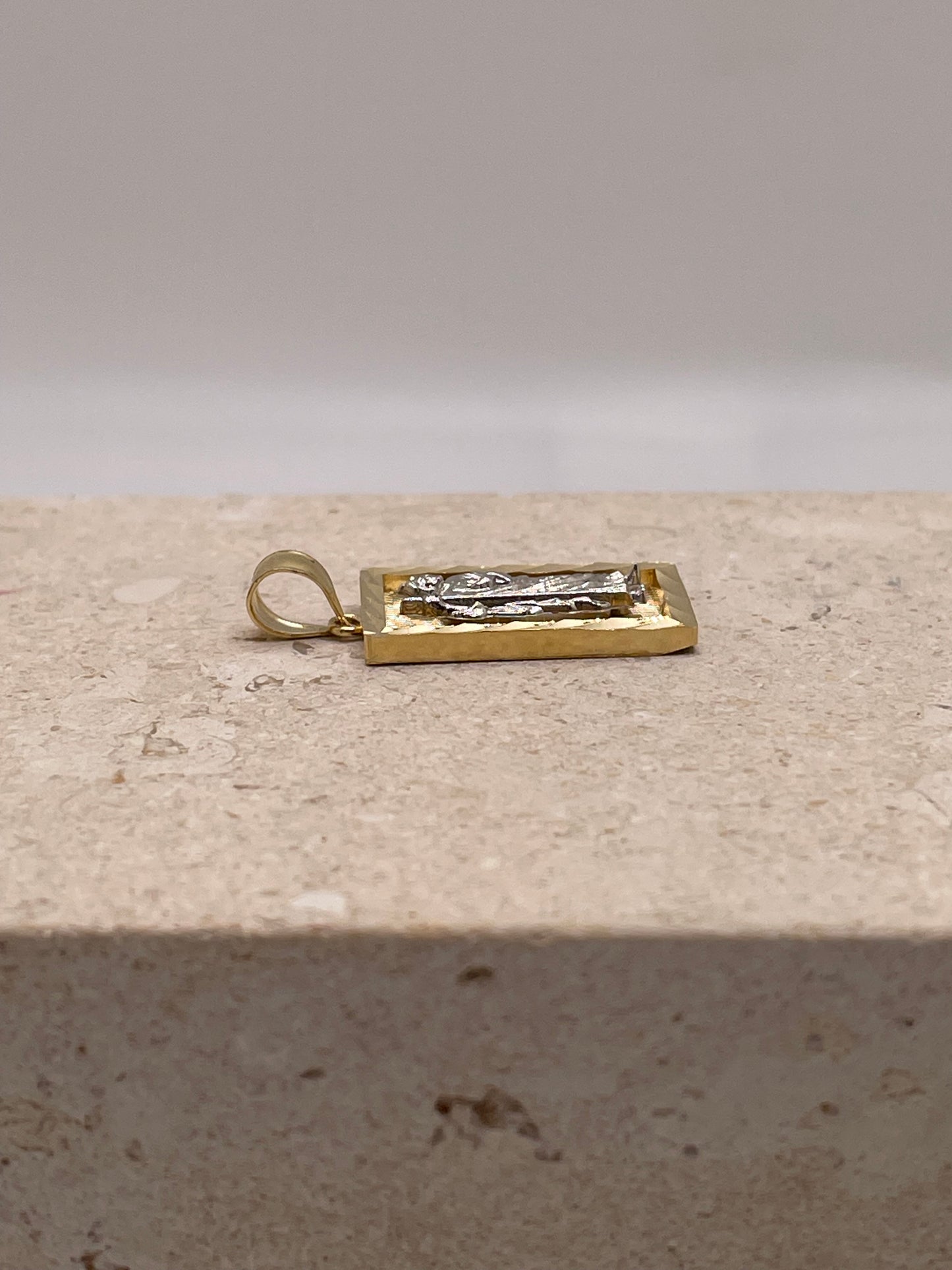 Side view of 14K two-tone gold San Judas pendant highlighting the bail size and design