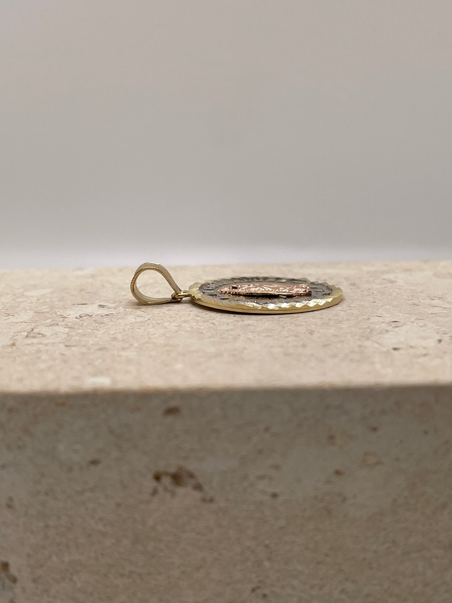 Side view of 14K gold Nuestra Senora De Guadalupe pendant showcasing the thickness and design of the pendant and bail