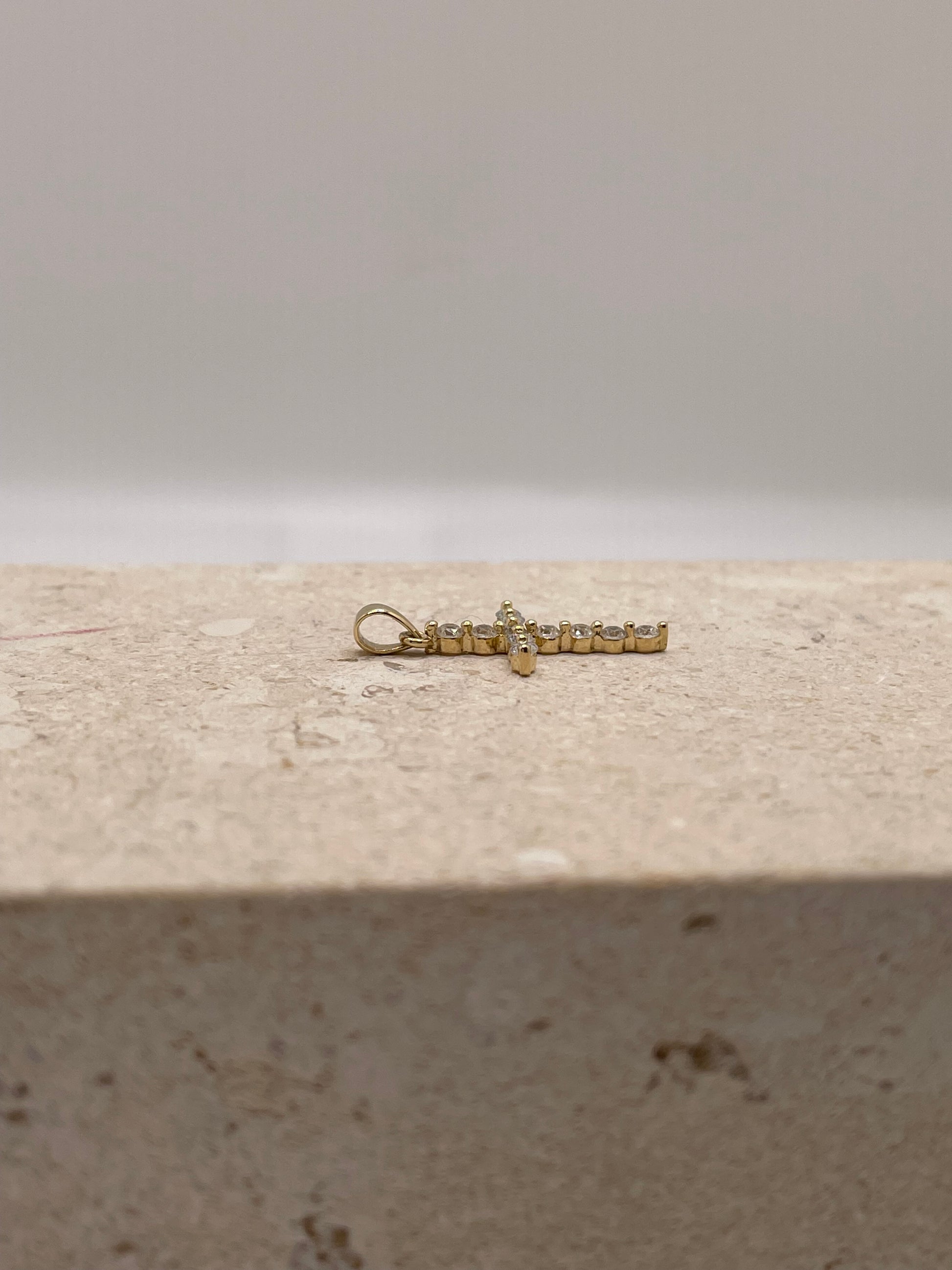 Side view of 14K yellow gold cross pendant with CZ stones and bail, showcasing depth and shine