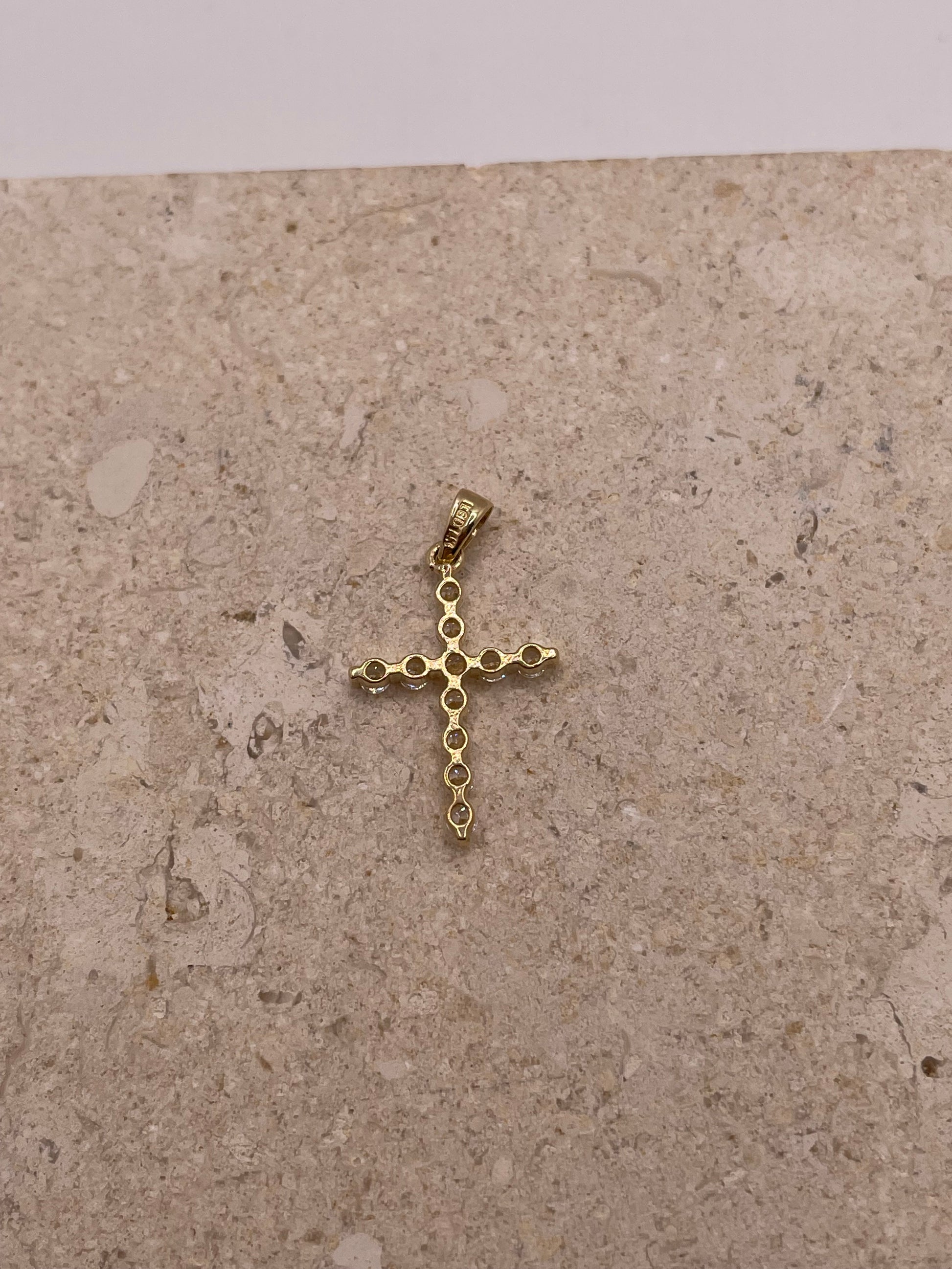 Back view of 14K yellow gold cross pendant with smooth polished finish and visible bail