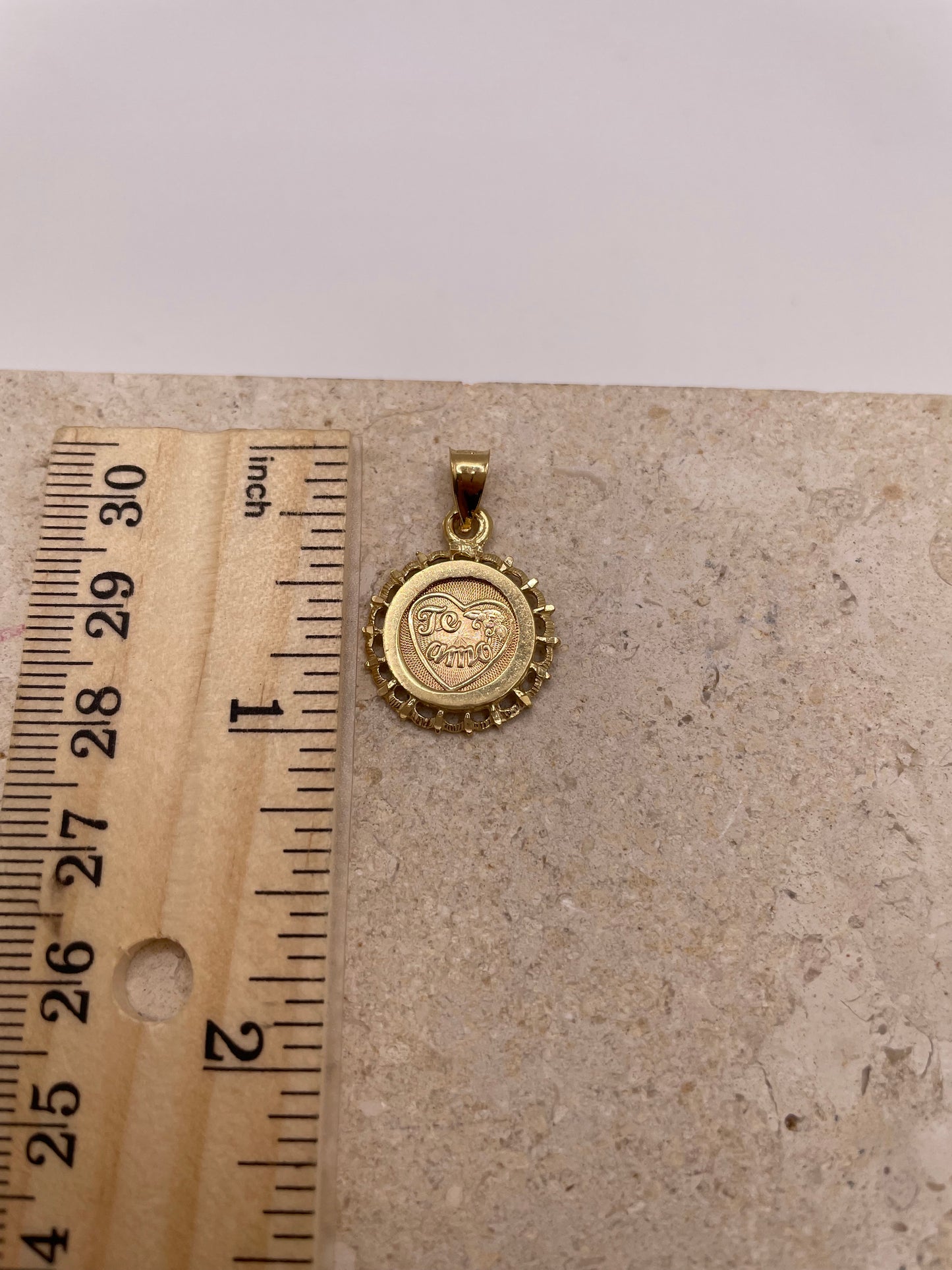 Ruler next to 14k Gold 'Te Amo' pendant showing 1-inch size