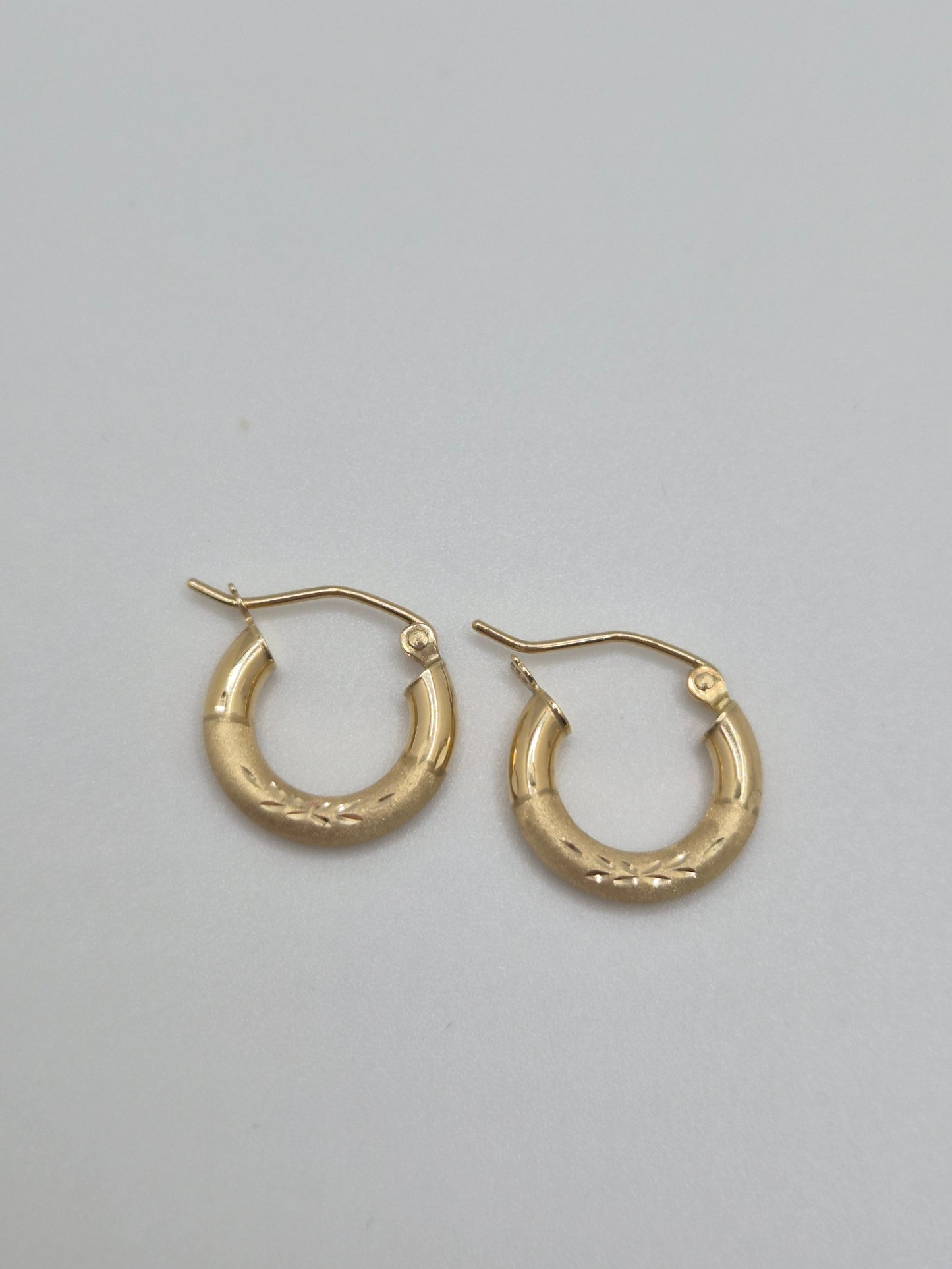 14K yellow gold mini hoop earrings with diamond-cut satin finish, 15mm lightweight everyday hoops.