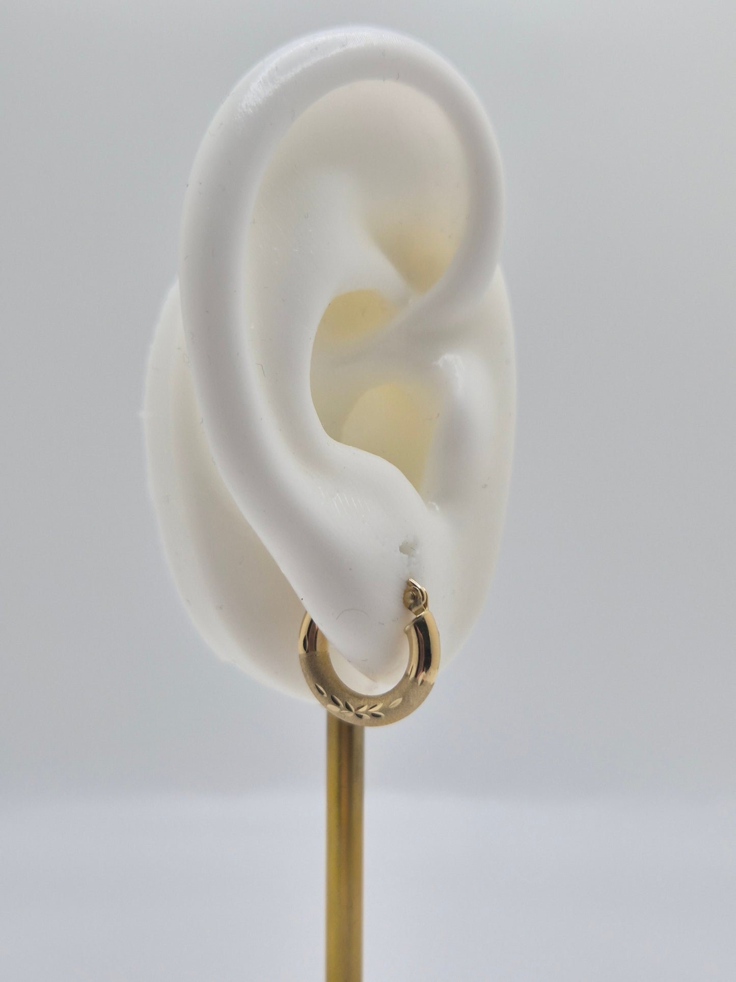 14K yellow gold mini hoop earrings with diamond-cut satin finish, 15mm lightweight everyday hoops.