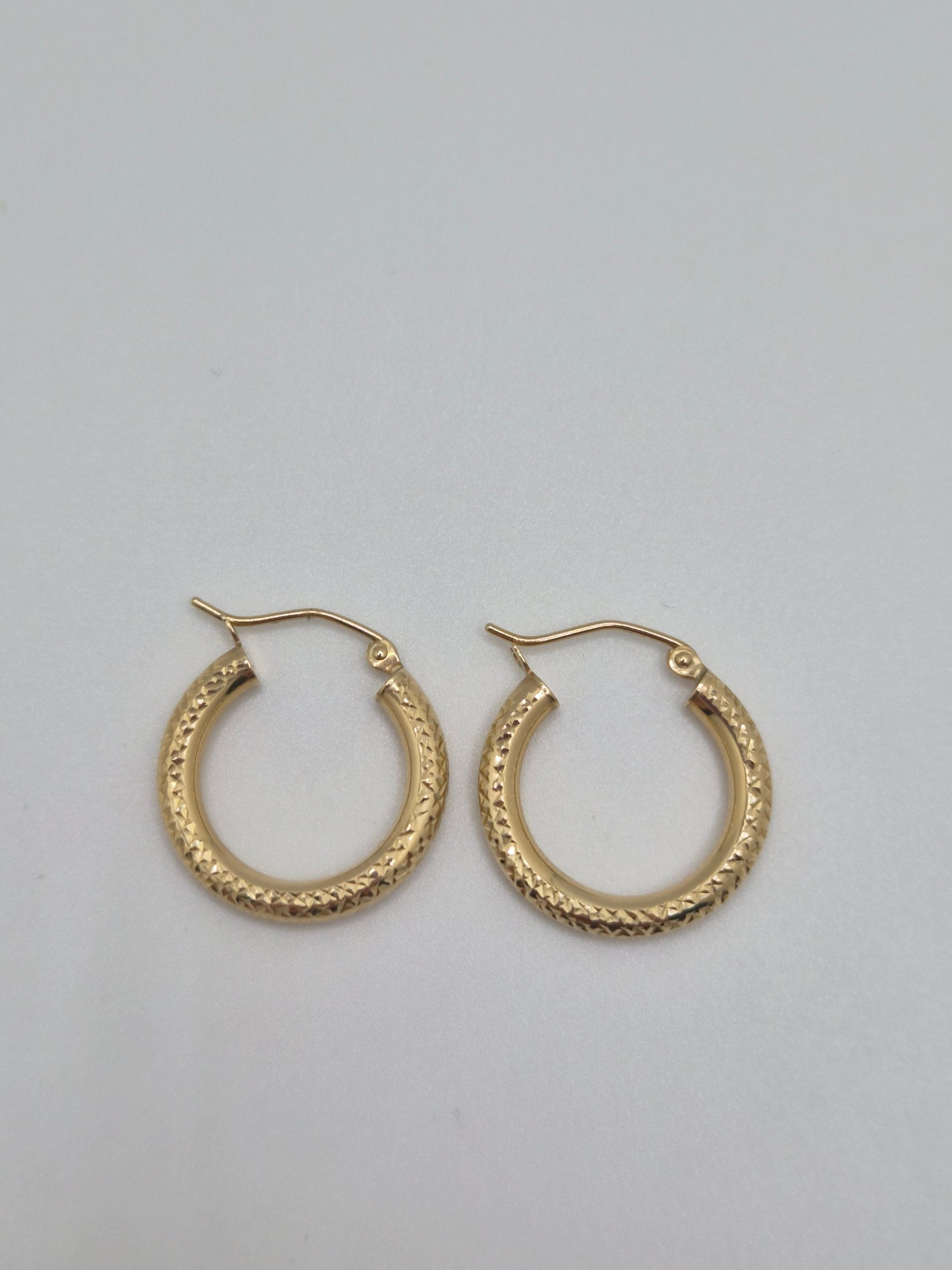 14K yellow gold diamond-cut mini hoop earrings, 20mm round lightweight design with textured shine.
