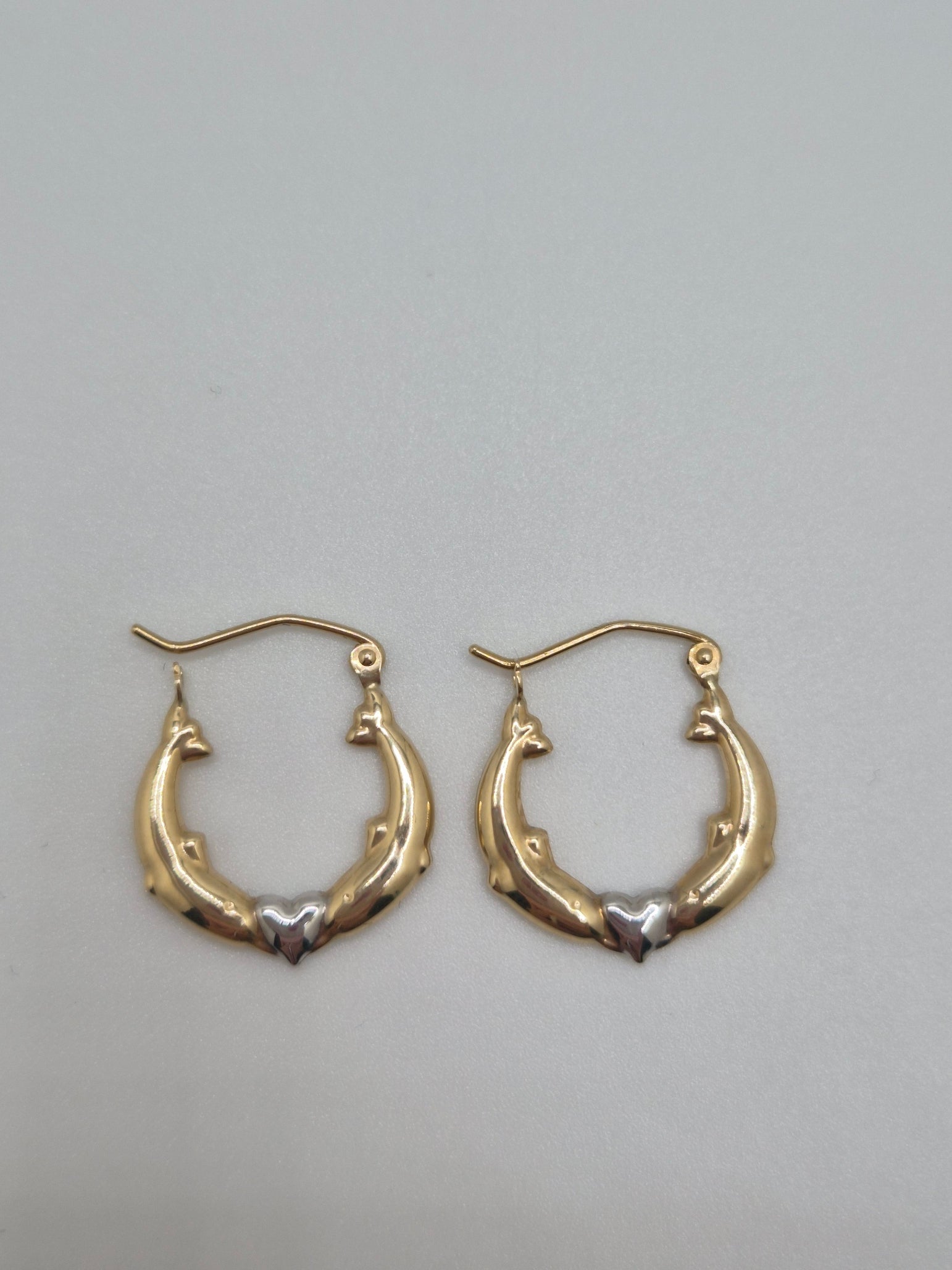 14K two-tone gold dolphin hoop earrings forming a heart design, 17mm lightweight hollow hoops.