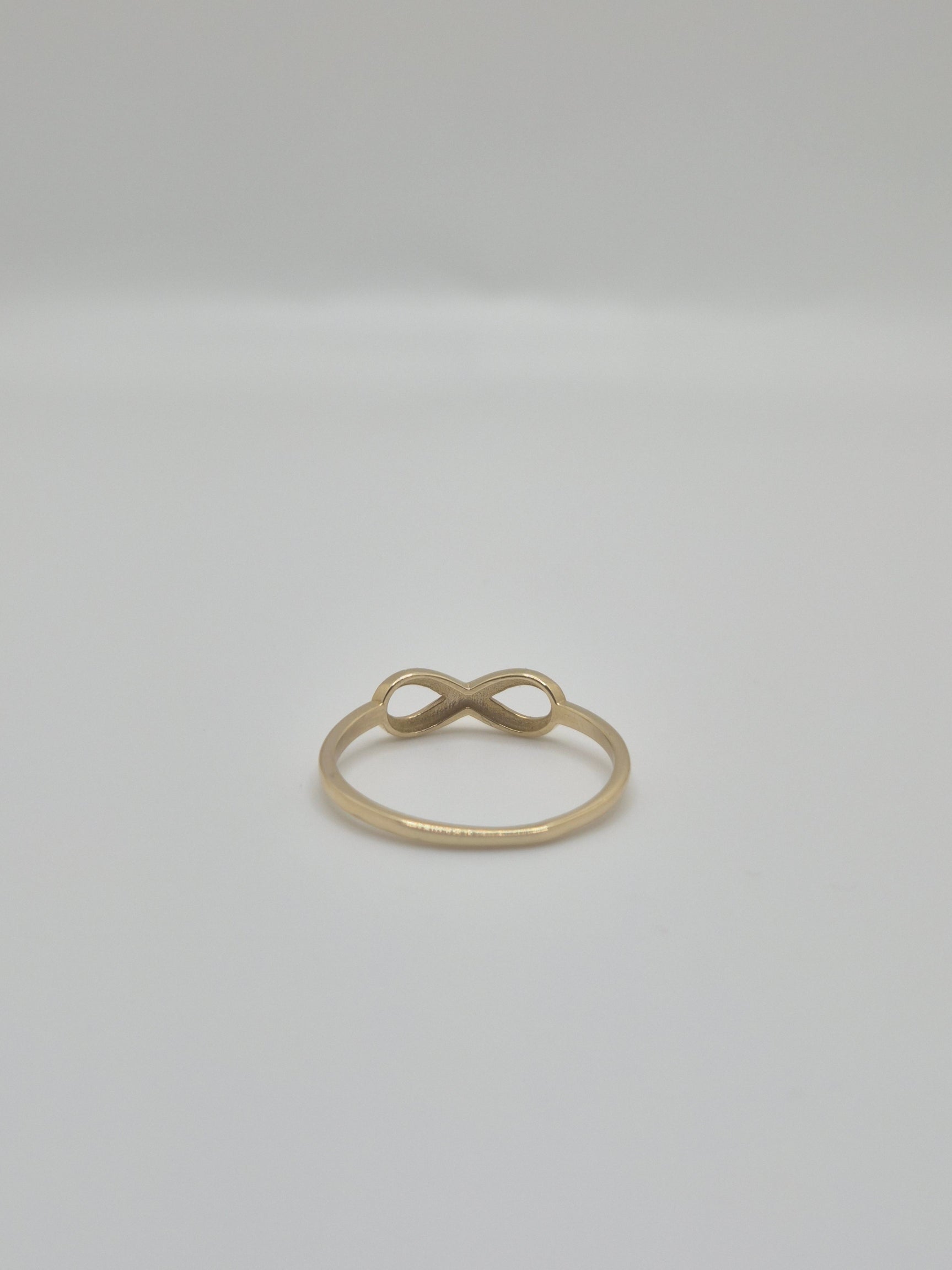 14K yellow gold infinity ring with polished finish, minimal everyday stacking band symbolizing eternal love.