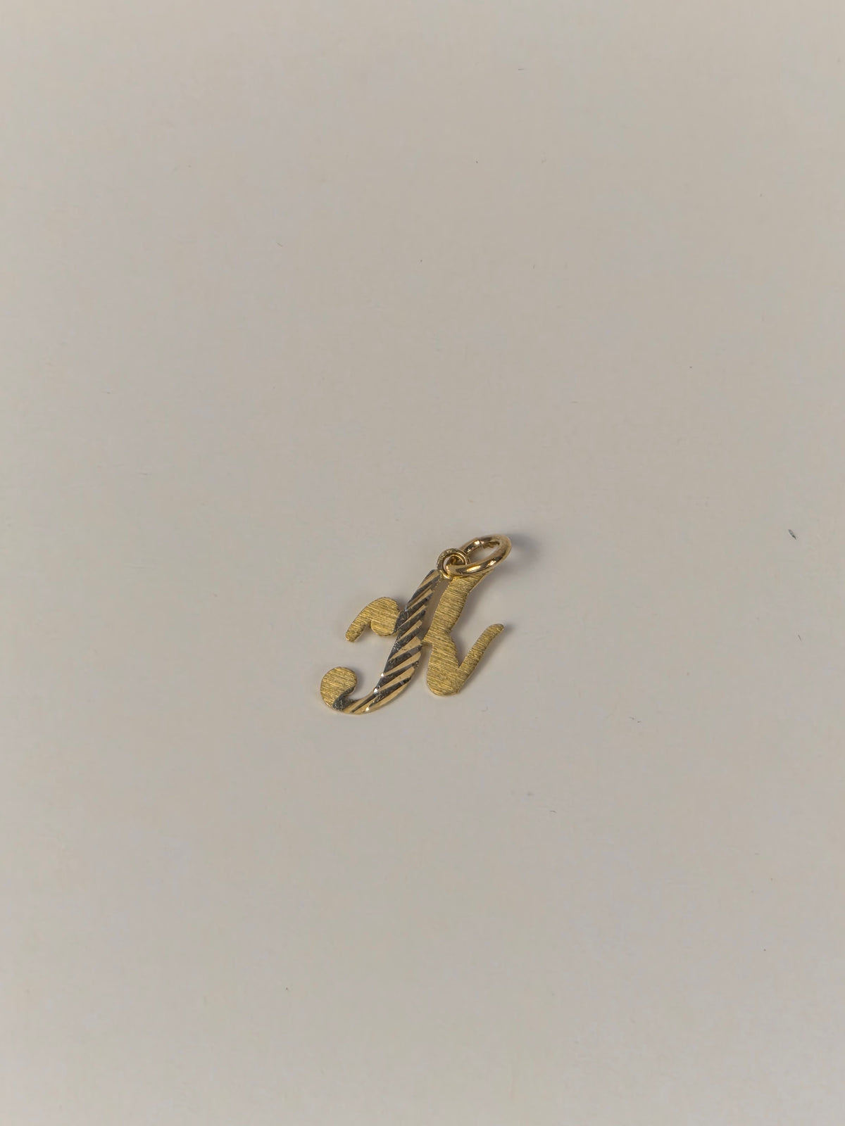 Colgante con inicial pequeña en cursiva con corte de diamante en oro de 14 quilates