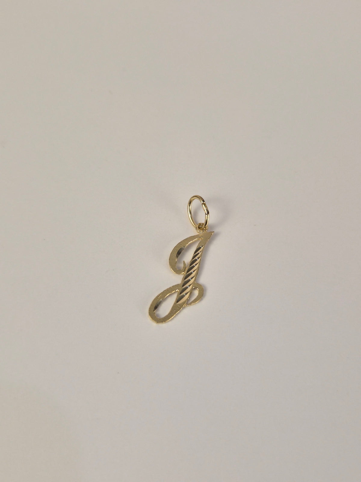 Colgante con inicial pequeña en cursiva con corte de diamante en oro de 14 quilates
