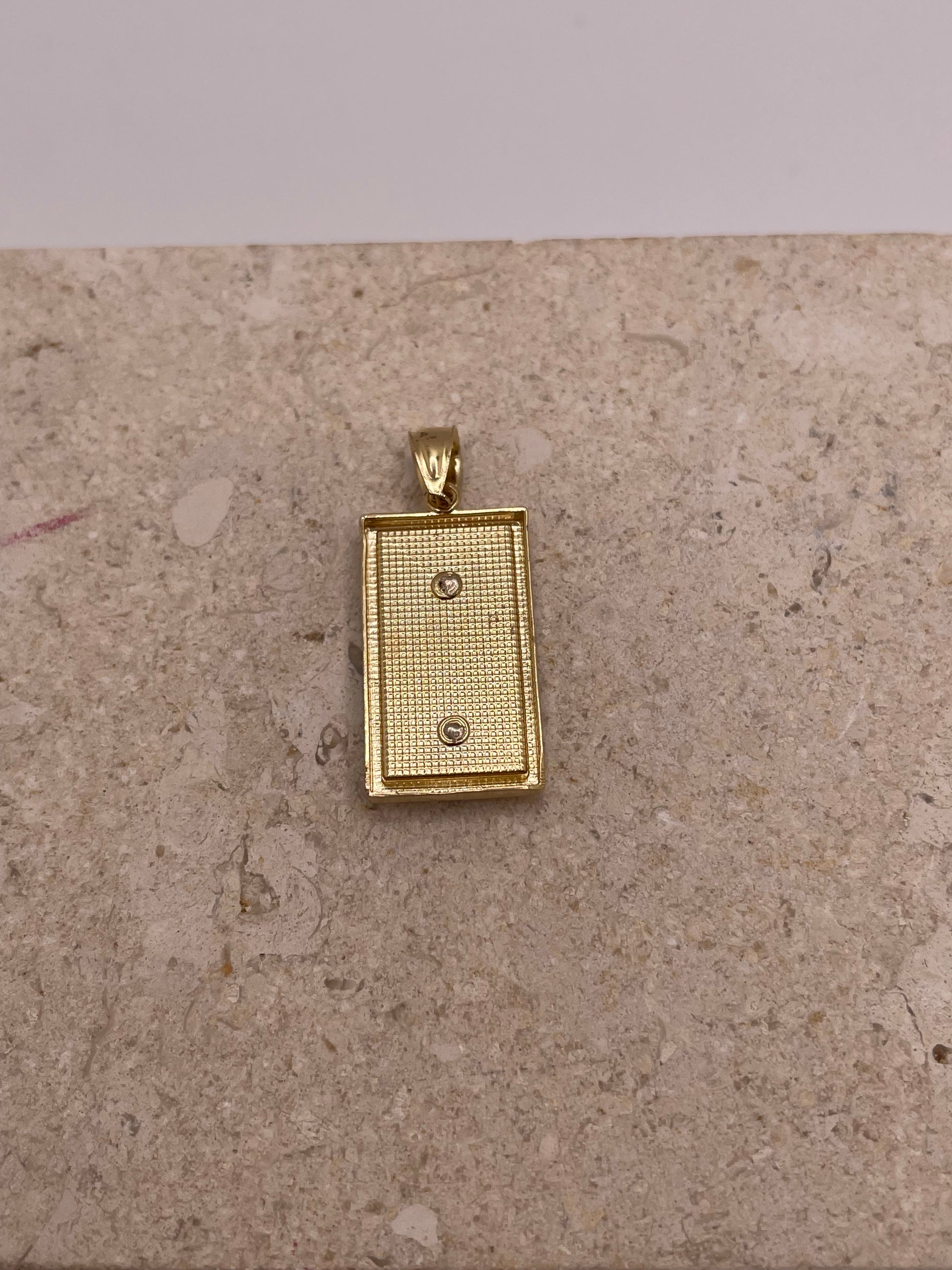 Back view of 14K two-tone gold San Judas pendant showing the smooth finish and craftsmanship