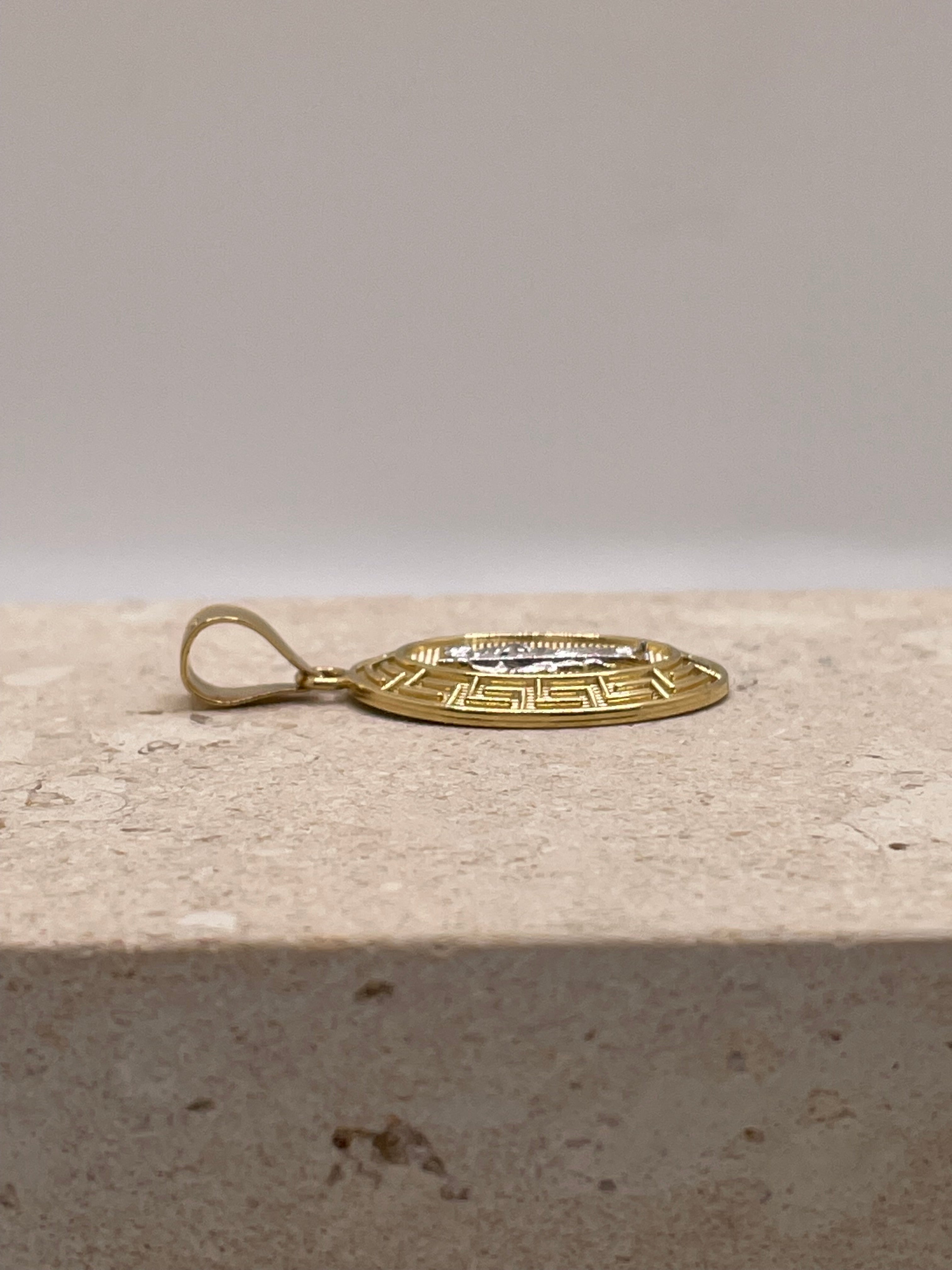 Side view of 14K yellow gold oval San Judas pendant emphasizing the bail size and design