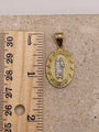 14K yellow gold oval San Judas pendant with white gold Saint Jude next to a ruler, showing pendant dimensions