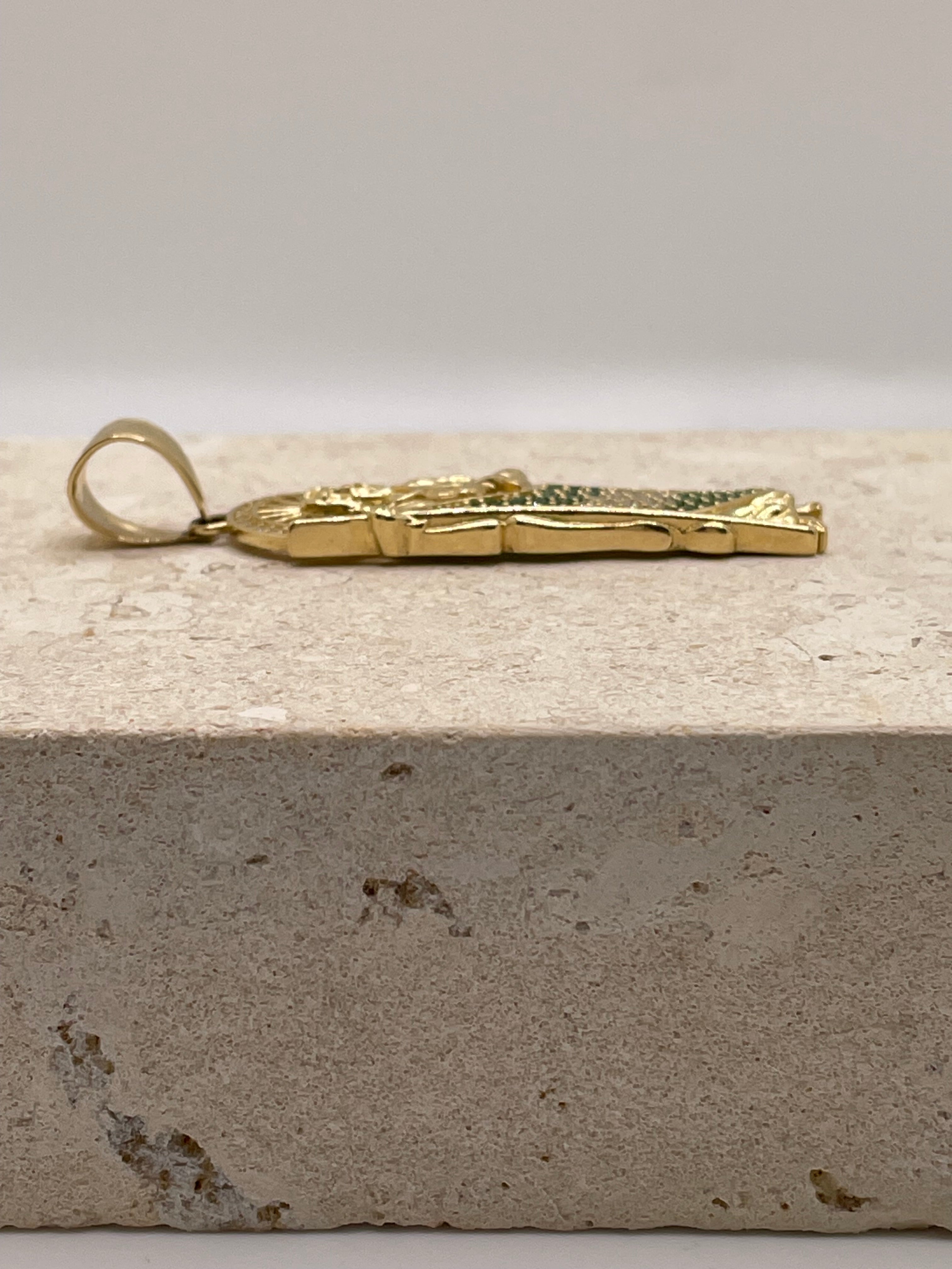 Side view of 14K yellow gold San Judas pendant highlighting the bail design and size