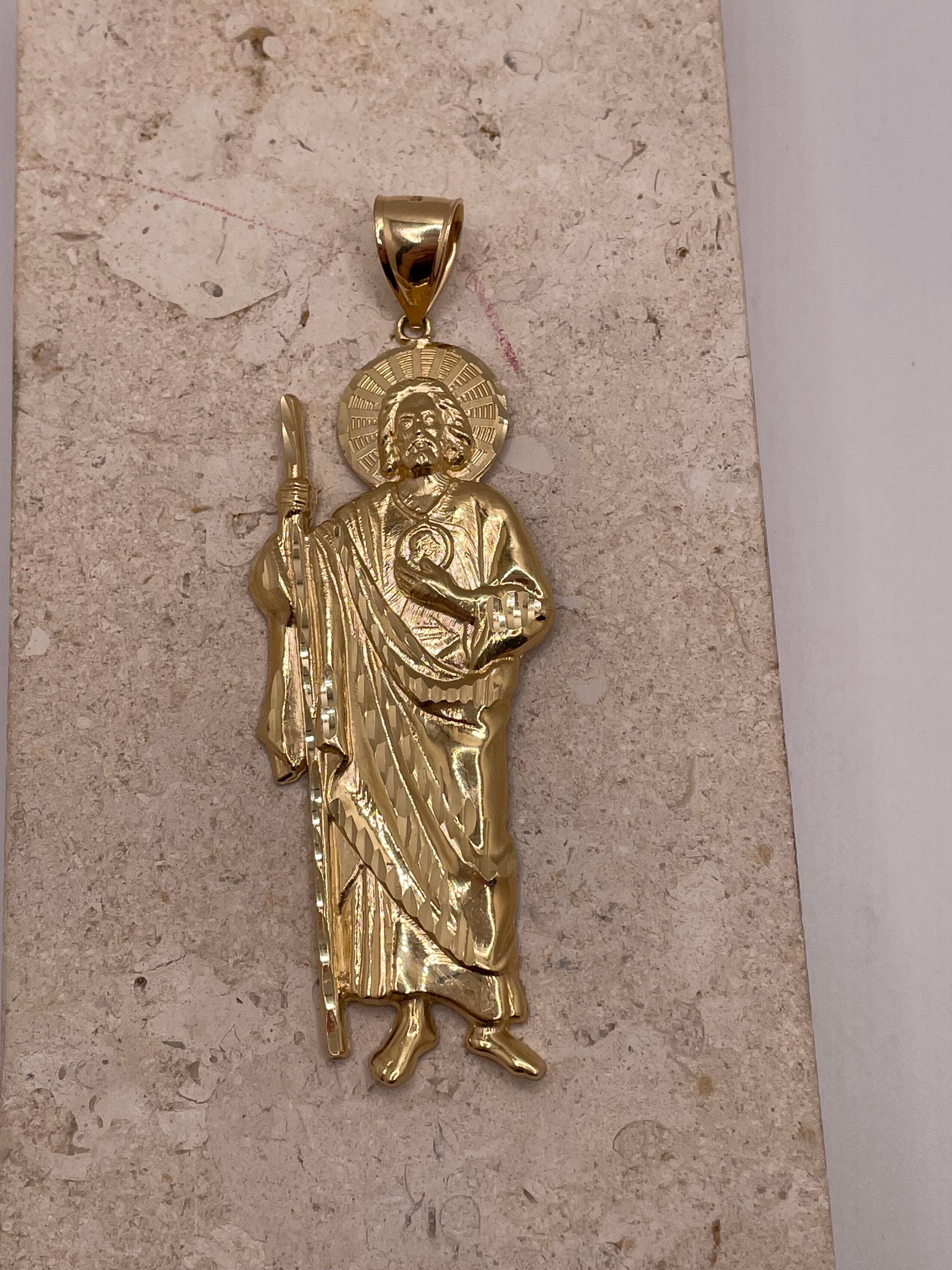 Close-up of 14K yellow gold large San Judas pendant with detailed craftsmanship and gold finish