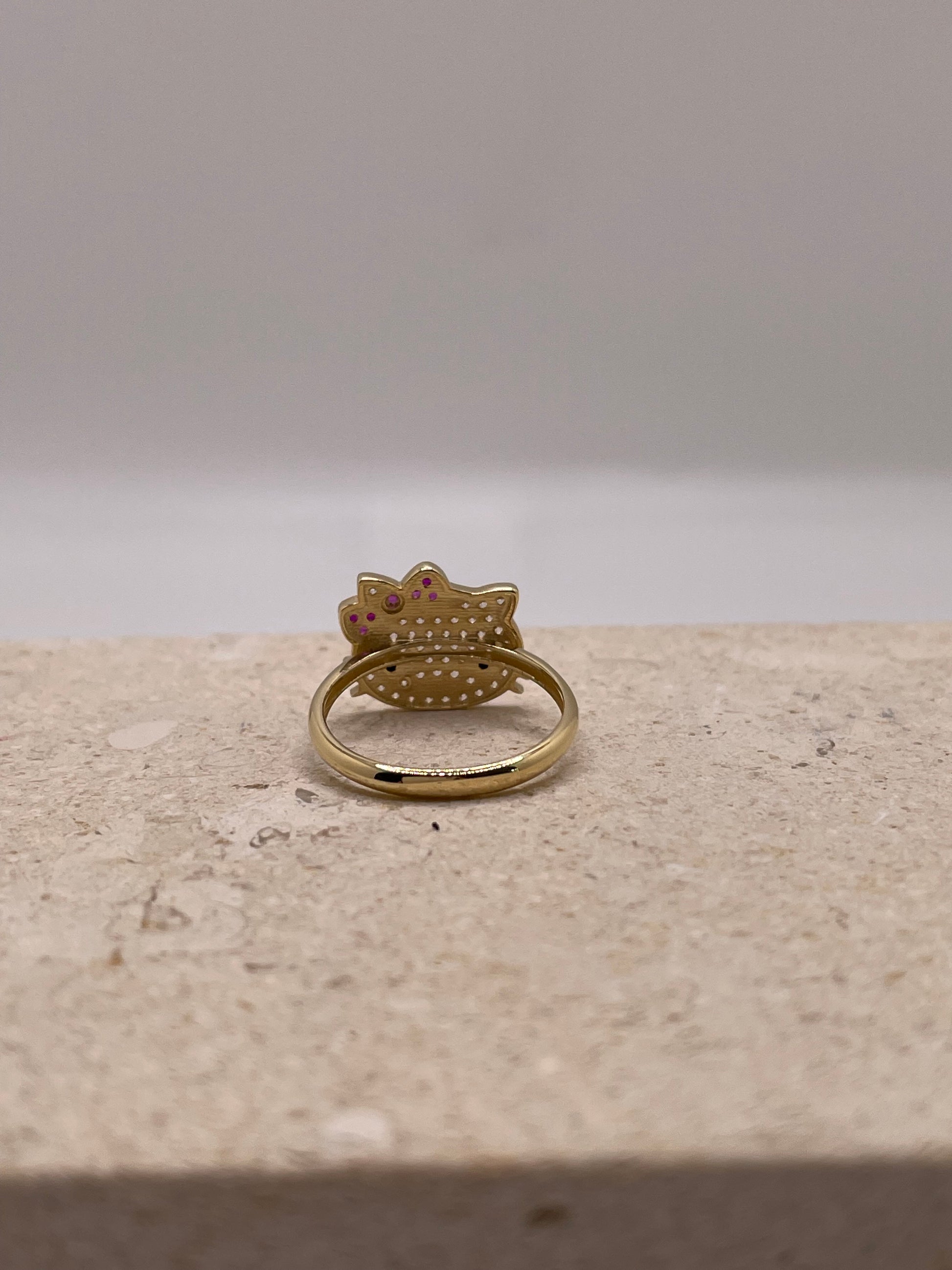 Back view of 14K gold Hello Kitty ring with smooth gold band and CZ stone accents.