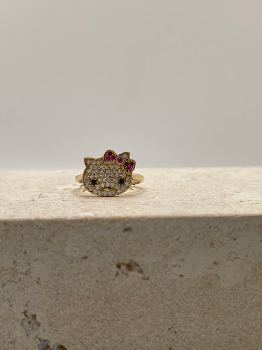 Close-up of 14K gold Hello Kitty ring with white CZ stones, black CZ eyes, and pink CZ bow
