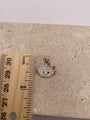 14K gold Hello Kitty pendant shown next to a ruler to display dimensions