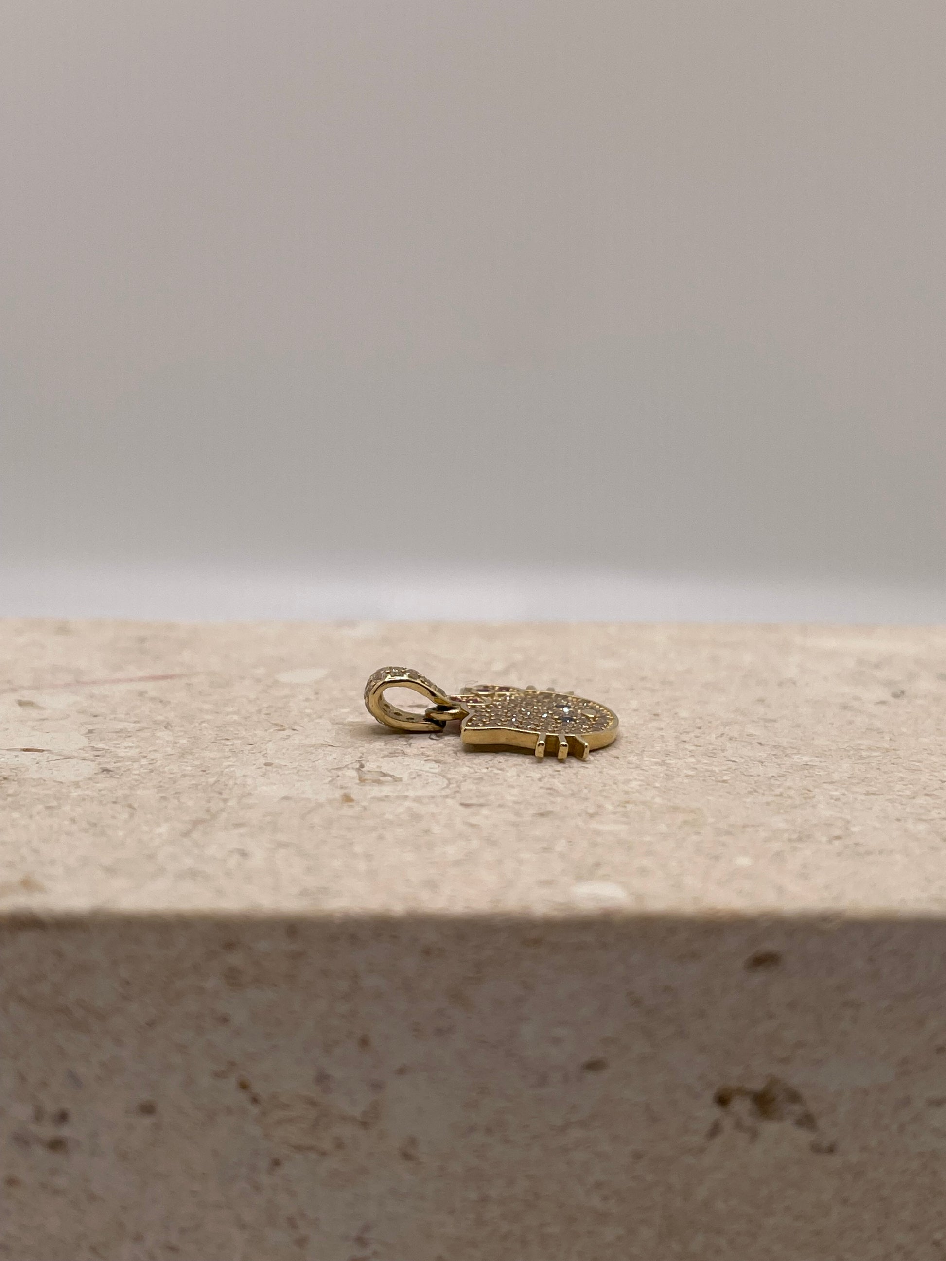 Side view of 14K gold Hello Kitty pendant showcasing the CZ stone details and gold finish