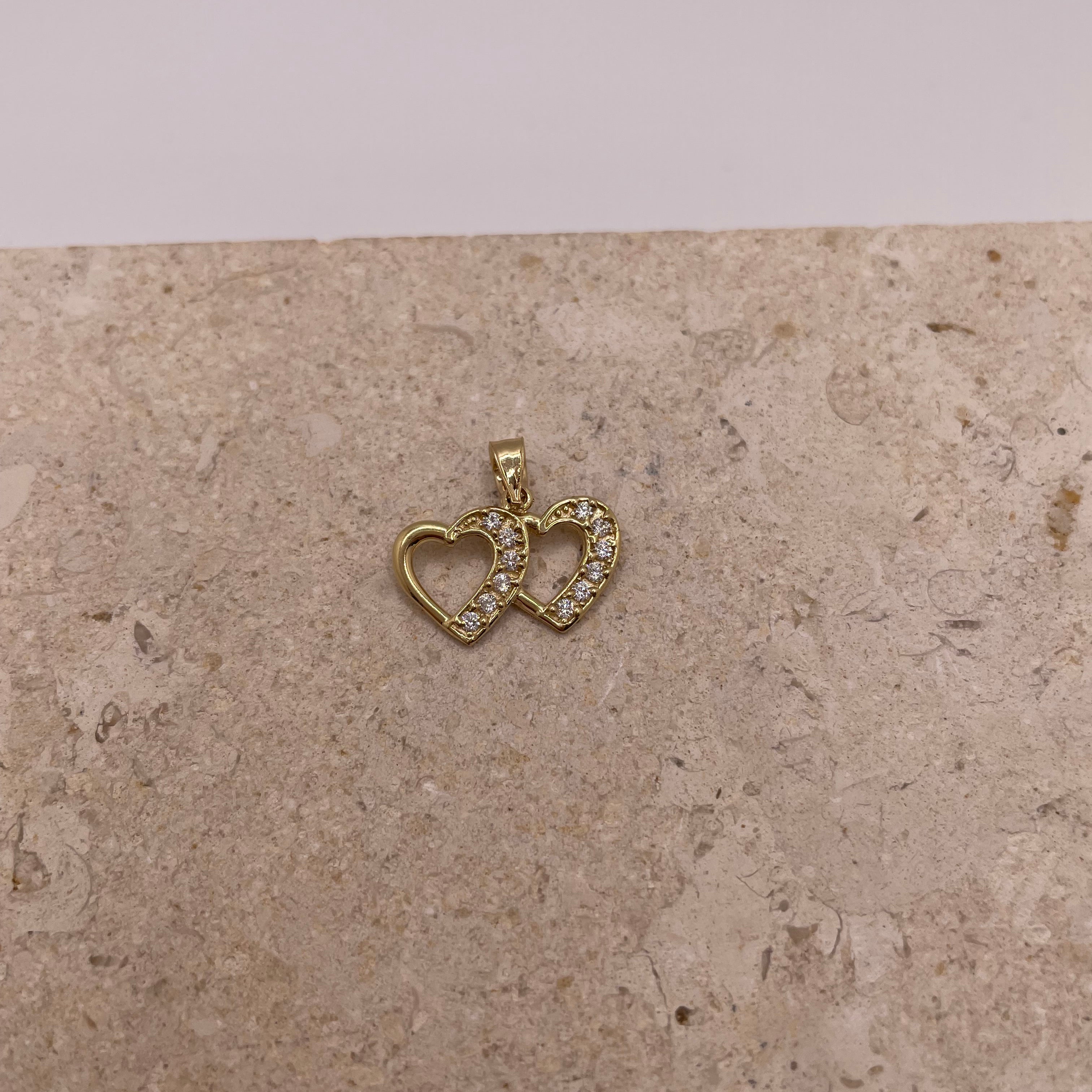 Close-up of 14K gold double heart pendant with CZ stones on the right heart