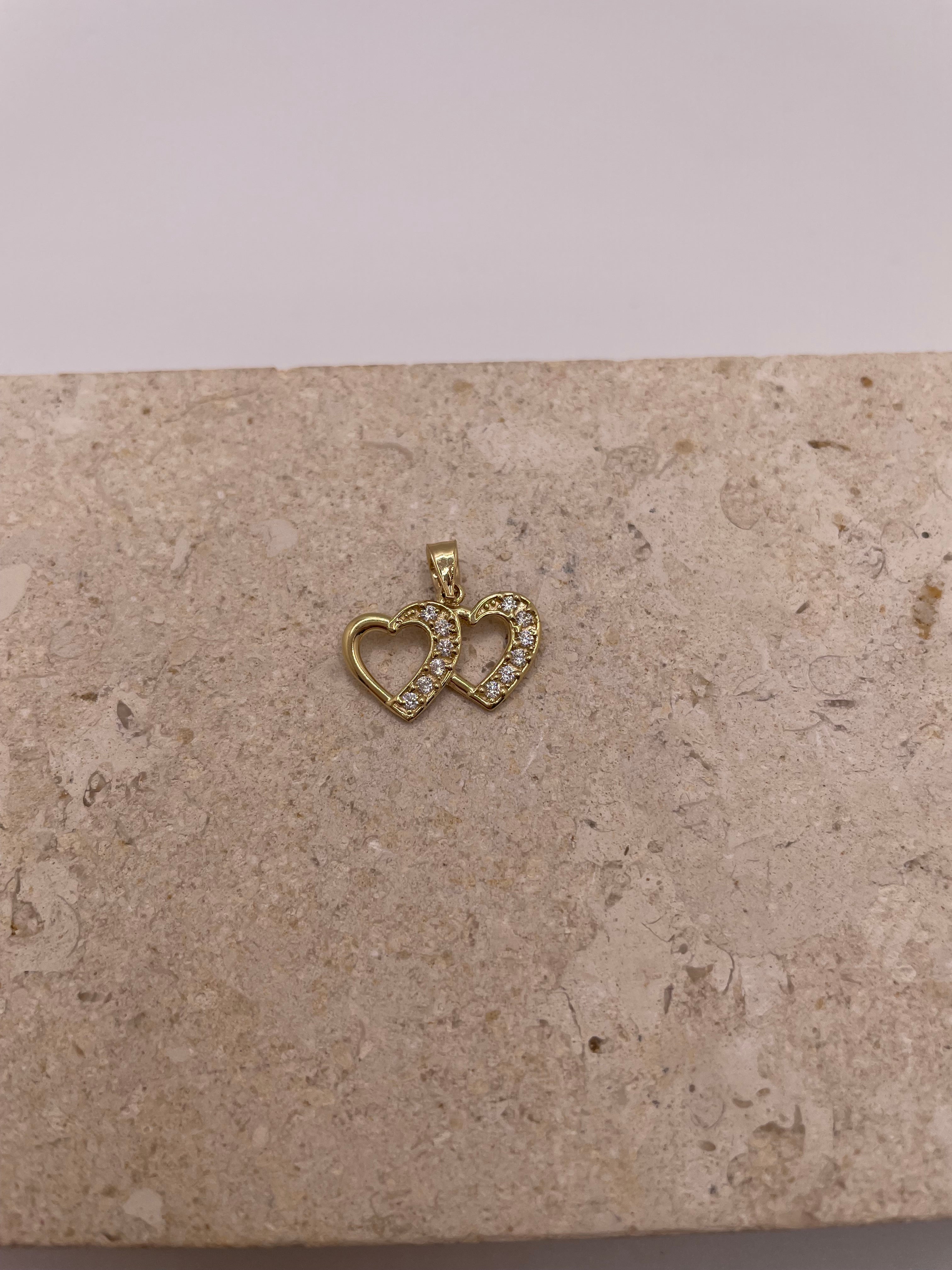 Close-up of 14K gold double heart pendant with CZ stones on the right heart