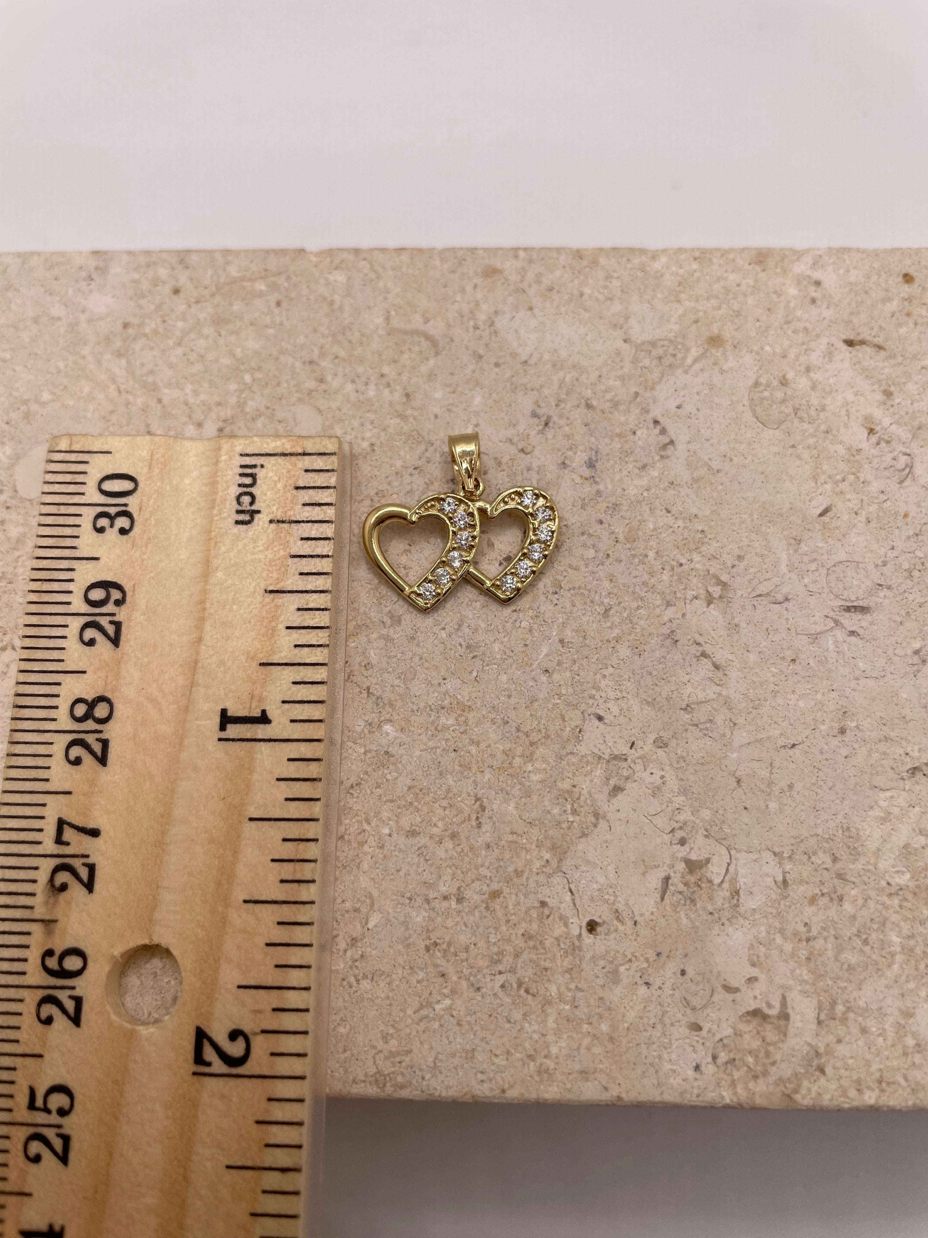 14K gold double heart pendant shown next to a ruler to display dimensions