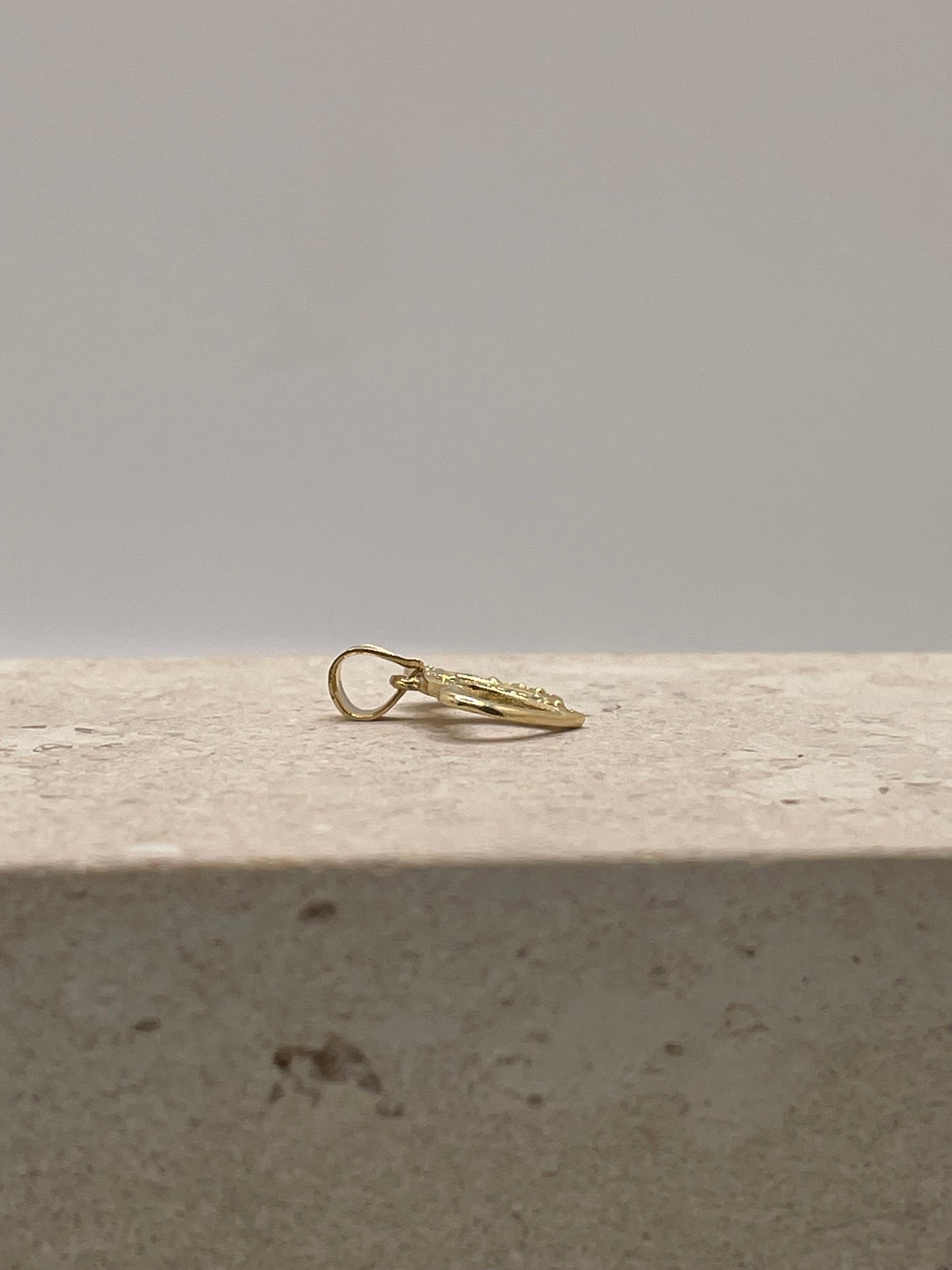 Side view of 14K gold double heart link pendant showing the depth and CZ detailing.