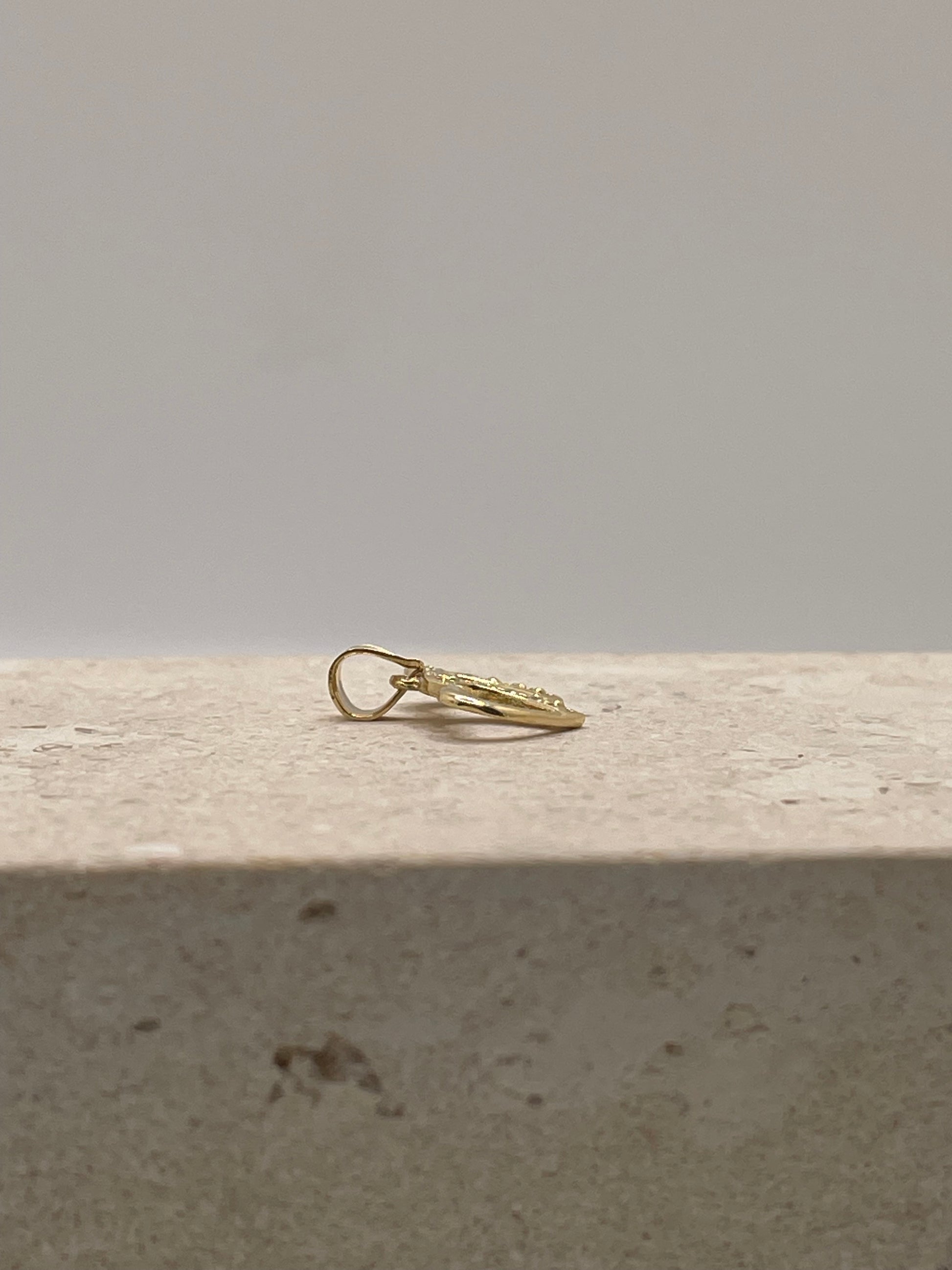 Side view of 14K gold double heart link pendant showing the depth and CZ detailing.