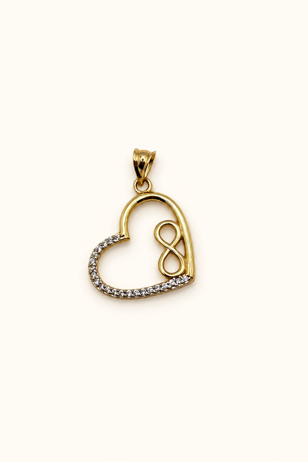 Close-up of 14K gold open heart pendant with small gold infinity symbol and white CZ stones on the left