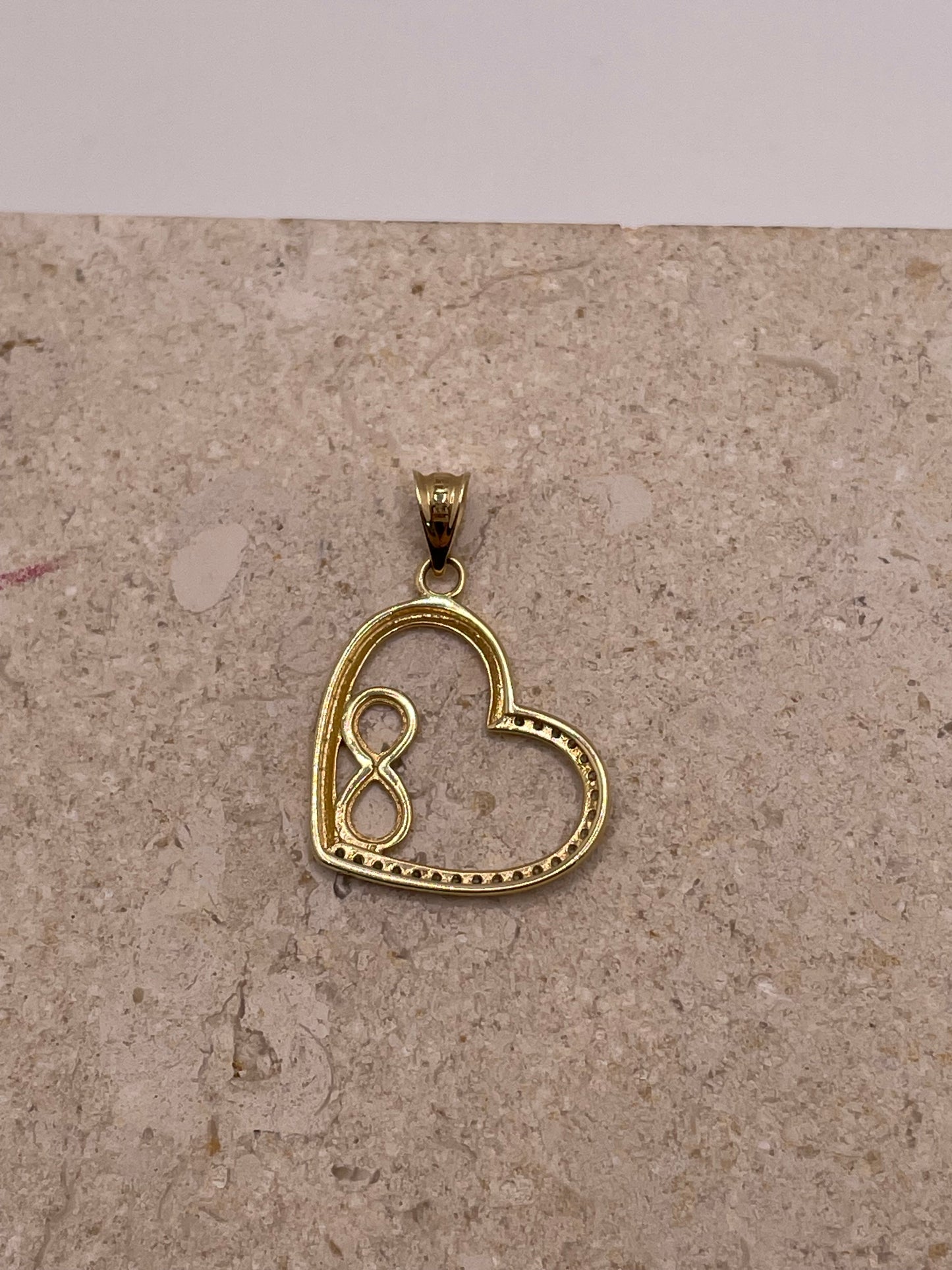Back view of 14K gold open heart pendant with smooth polished finish and side bai