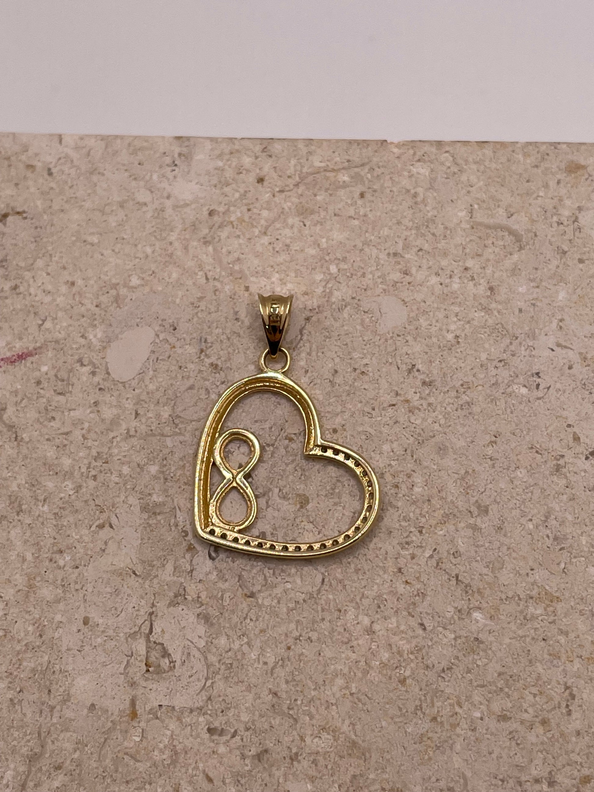 Back view of 14K gold open heart pendant with smooth polished finish and side bai