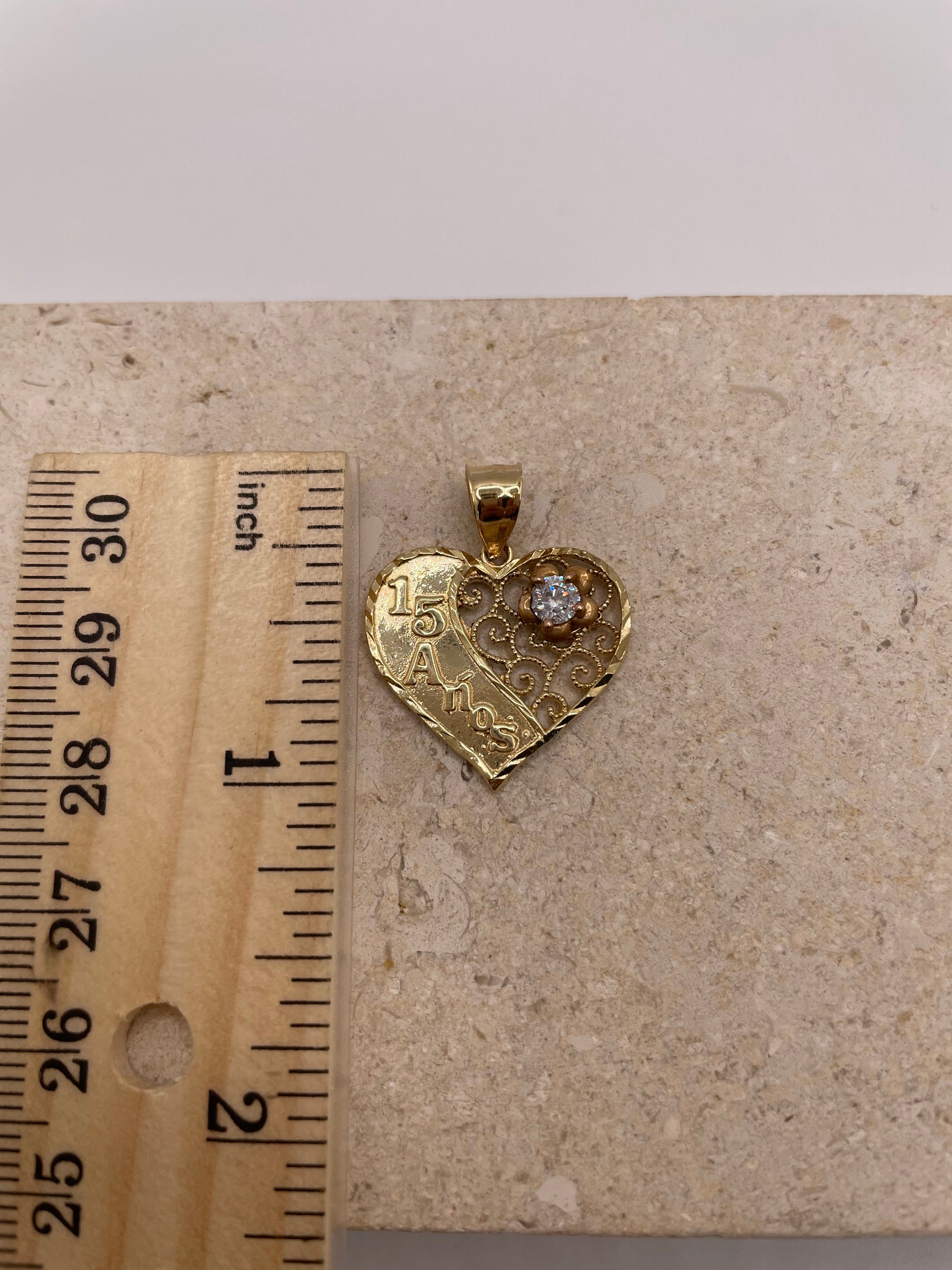 Ruler next to 14k Gold Quinceañera pendant showing 1-inch size.
