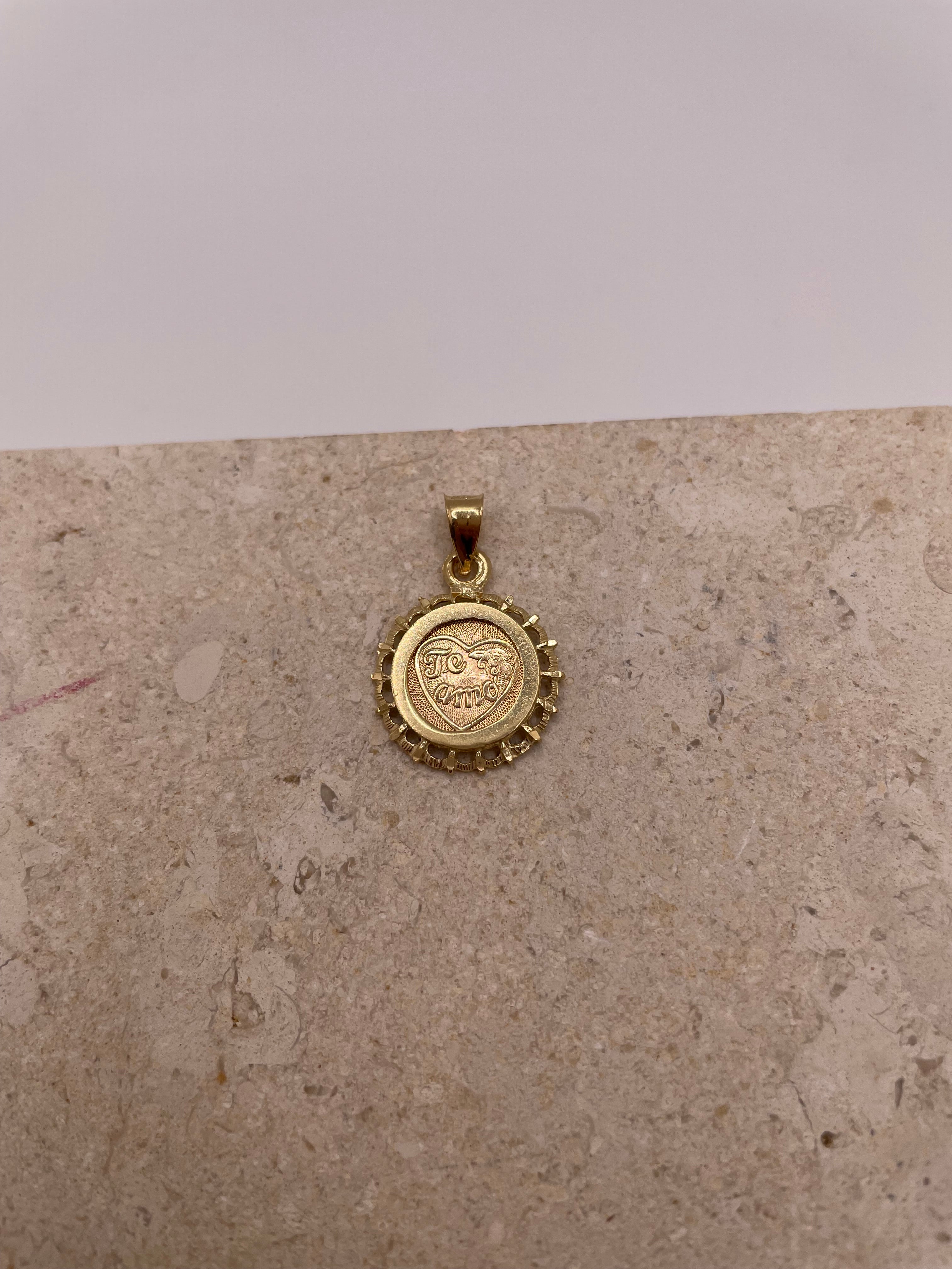 Close-up of 14k Gold 'Te Amo' pendant with heart and flower detail