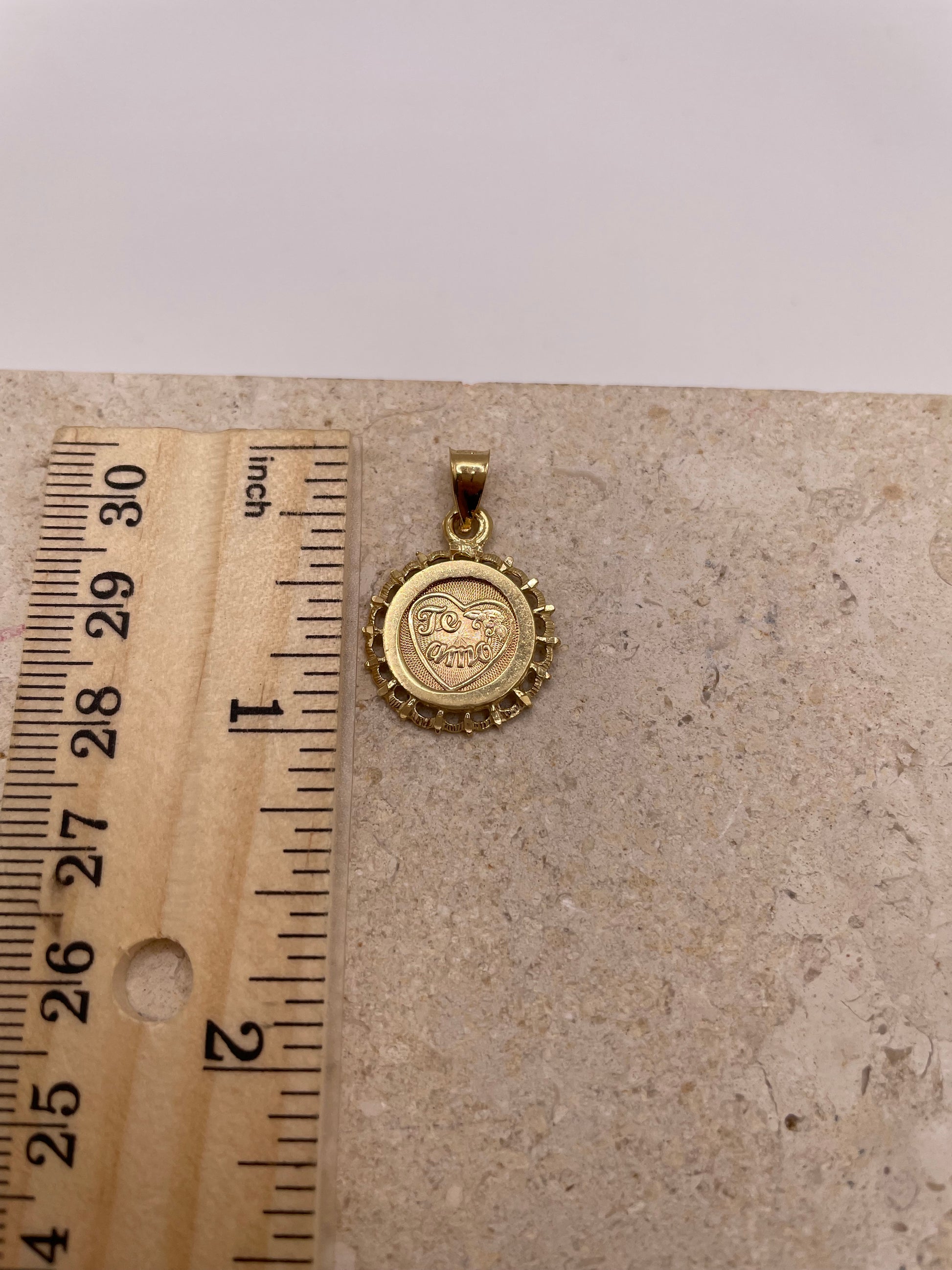 Ruler next to 14k Gold 'Te Amo' pendant showing 1-inch size