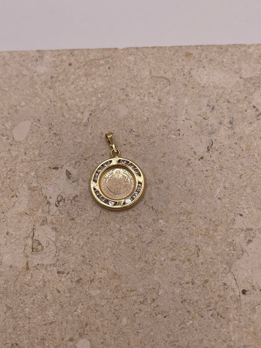 A close-up image of the 14k gold San Benito pendant featuring the detailed design of the Saint Benedict medal at the center, surrounded by a sparkling border of cubic zirconia stones.